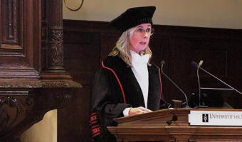 Afbeelding met Menselijk gezicht, persoon, kleding, microfoon 